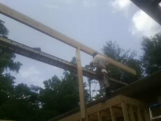 Carpenter setting a ridge beam over a new addition frame — Ice Dam Removal by Roofing Brothers in Pleasanton